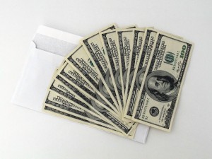 one hundred dollar bills above an envelope